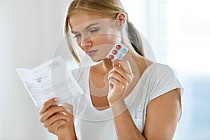 Woman Taking Medicine. Female With Pills Reading Instructions