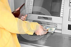 Woman taking money from cash machine, closeup