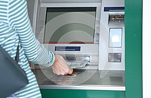 Woman taking money from cash machine outdoors, closeup