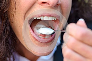 Woman taking a mouthful of cream or ice cream