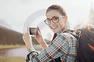 Woman taking nature photos with her phone