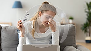 Woman taking off glasses, suffering from eyes fatigue after computer work