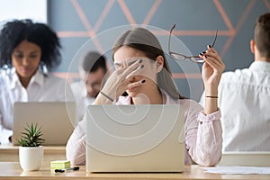 Woman taking off glasses tired of work, eyes fatigue concept