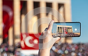 Woman taking photo of anitkabir mausoleum in crowd