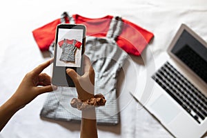 Woman taking a photo of an article of clothing to sell online. Concept of selling clothes online.