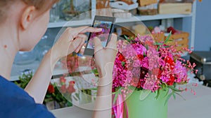 Woman taking photo of beautiful bouquet with smartphone