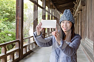 Woman taking photo with cellphone in japanese old house