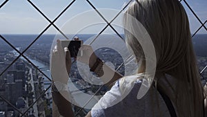 Woman taking photo of cityscape with smartphone