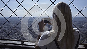 Woman taking photo of cityscape with smartphone