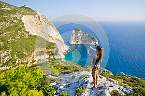 Woman taking photo of cliff - Zakynthos island, Agalas, Greece