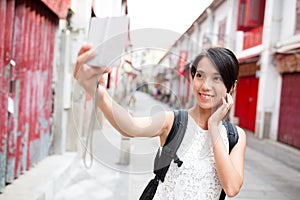Woman taking photo by digital camera in Macao old town photo