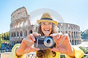Woman taking photo in front of colosseum in rome