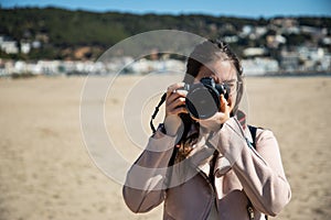 Woman taking photo front view with DSLR camera