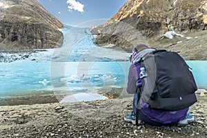 Woman taking a photo of a glacier