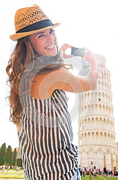 Woman taking photo of leaning tower of pisa, tusca