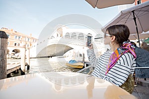 Woman taking photo at outdoor cafe in Venice, Italy