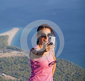 Woman taking a photo on the rocks of Vidova Gora, the mountain of Saint Vid, BraÄ island in Croatia, Mediterrane