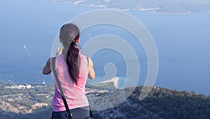 Woman taking a photo on the rocks of Vidova Gora, the mountain of Saint Vid, BraÄ island in Croatia, Mediterrane