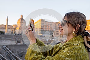 Woman taking photo of Roman forum, while traveling in Rome