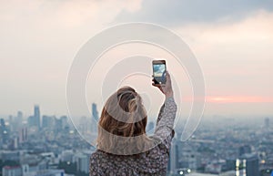 Woman taking a photo of the sunset