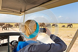 Woman taking photos on african wildlife safari. Amboseli, Kenya.