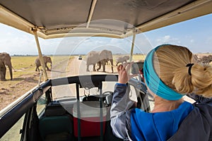 Woman taking photos on african wildlife safari. Amboseli, Kenya.