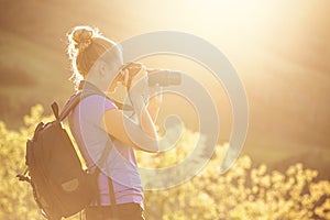 Woman taking photos outdoors on a sunny evening