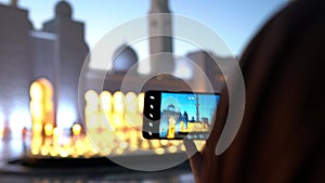 Woman taking photos with a smart phone of a mosque at sunset | Abu Dhabi Sheik Zayed Mosque | Beautiful islamic architecture