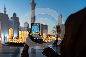 Woman taking photos with a smart phone of a mosque at sunset | Abu Dhabi Sheik Zayed Mosque | Beautiful islamic architecture | Tou