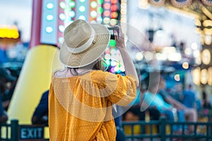 Woman taking picture at amusement park during her travel at summer vacation