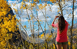 Woman Taking Picture of aspen tree, sunny autumn day Colorado