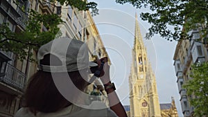 Woman taking picture of cathedral