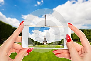 Woman taking a picture of Eiffel tower in Paris