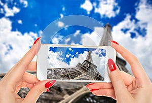 Woman taking a picture of famous Eiffel Tower in Paris