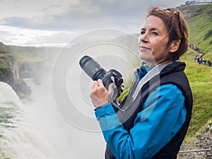 Woman is taking a picture at a Gullfoss waterfall - Iceland