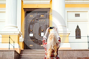 Woman taking picture on her mobile phone during vacation. Travel to european city