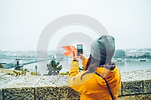 Woman taking picture on her phone of the old european city