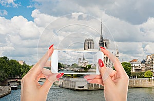 Woman taking a picture of Notre Dame de Paris Cathedral.Paris