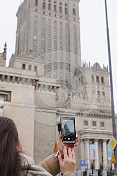 Woman is taking a picture of sightsee in city via her mobile phone. Travelling