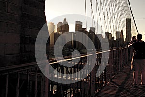 Woman taking a picture to Manhattan views at Brooklyn Bridge. Ne