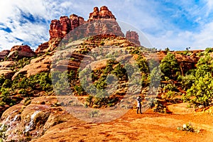 Woman taking a picture of the vegetation on Bell Rock, one of the famous red rocks between the Village of Oak Creek and Sedona