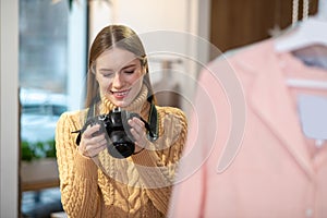 Woman taking pictures of clothes using professional camera