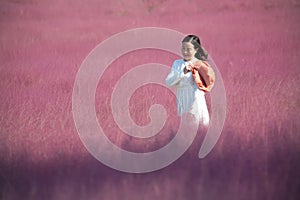 A woman taking pictures among the tangled grass and flowers