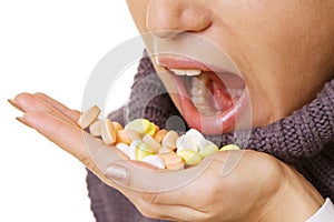 Woman taking pills over white