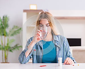 Woman taking pills to cope with pain