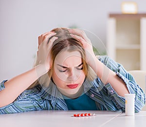 Woman taking pills to cope with pain