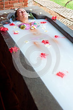 Woman taking pleasure in milk bath