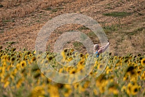 Woman taking selfie in field of sunflowers in Chorleywood, Hertfordshire UK. The sunflowers are grown for their seeds.