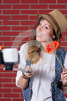 Woman taking selfie in front of brick wall