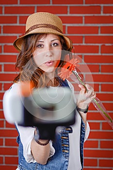 Woman taking selfie in front of brick wall